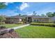 Charming single-story home featuring lush landscaping, a well-manicured lawn, and a welcoming front entrance at 6911 Wildberry Ln, Lakeland, FL 33813