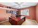 Home office features a large desk, a ceiling fan, and framed artwork at 6911 Wildberry Ln, Lakeland, FL 33813