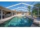 Covered lanai with enclosed pool area, outdoor seating, and garden views at 6911 Wildberry Ln, Lakeland, FL 33813