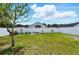 Spacious backyard featuring lush green grass, white privacy fence, and beautiful landscaping at 7139 Cedarcrest Blvd, Lakeland, FL 33810