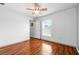 Bright bedroom features hardwood floors, a ceiling fan, and natural light from a window at 7139 Cedarcrest Blvd, Lakeland, FL 33810