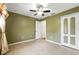 Neutral bedroom with tile floor, closet, ceiling fan, and olive-green accent wall at 7139 Cedarcrest Blvd, Lakeland, FL 33810