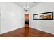 Open-concept living room featuring wood-look flooring, chandelier, and a view into a separate office space at 7139 Cedarcrest Blvd, Lakeland, FL 33810