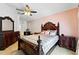 Main bedroom suite features elegant wood furniture, ceiling fan, and ensuite bath at 7139 Cedarcrest Blvd, Lakeland, FL 33810