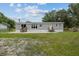 Back exterior of the home featuring two sets of stairs and large concrete patio at 7202 Glen Meadow Dr, Lakeland, FL 33810
