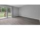 Bright living room with wood-look flooring and sliding glass doors to a wooden deck at 7202 Glen Meadow Dr, Lakeland, FL 33810