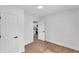 Minimalist bedroom featuring white walls and light wood floors, open to another area of the house at 828 E Valencia St, Lakeland, FL 33805