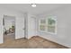 This bedroom features wood-look floors, neutral colors and a connecting door to the office at 828 E Valencia St, Lakeland, FL 33805