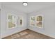Corner bedroom with light wood floors and white walls, featuring natural light through two windows at 828 E Valencia St, Lakeland, FL 33805