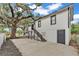 White two-story home featuring black trim, modern stairs, and a large yard with mature trees at 828 E Valencia St, Lakeland, FL 33805