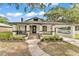 Inviting home features a covered front porch, well-manicured landscaping, and a charming walkway at 828 E Valencia St, Lakeland, FL 33805