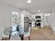 Modern white kitchen with stainless steel appliances, light wood floors, and a glass dining table at 828 E Valencia St, Lakeland, FL 33805