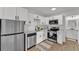 Modern kitchen featuring stainless steel appliances, white cabinets, and light wood flooring at 828 E Valencia St, Lakeland, FL 33805