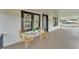 Inviting front porch featuring white siding, black trim, and two cozy wicker chairs with tropical print pillows at 828 E Valencia St, Lakeland, FL 33805