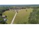 Acreage featuring a well-maintained home, outbuildings, a long driveway, and vast green fields with lush trees at 8337 Fussell Rd, Polk City, FL 33868