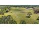 Scenic aerial perspective of a lush property with interspersed woodlands and featuring a home and outbuildings at 8337 Fussell Rd, Polk City, FL 33868