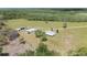Expansive aerial view of the rural property with home, outbuildings, and a private, wooded setting at 8337 Fussell Rd, Polk City, FL 33868