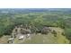 Aerial view of a spacious property with a house and outbuildings, surrounded by lush greenery and trees at 8337 Fussell Rd, Polk City, FL 33868