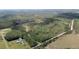 A sprawling property featuring a residence, outbuildings, and a mix of green fields and dense wooded areas at 8337 Fussell Rd, Polk City, FL 33868