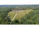 Expansive aerial view of a sprawling estate featuring verdant pastures, mature trees, and multiple buildings at 8337 Fussell Rd, Polk City, FL 33868