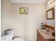 A cozy half-bathroom featuring wood-paneled walls, a small vanity, and framed artwork at 8337 Fussell Rd, Polk City, FL 33868