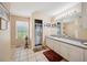 Bathroom with window, large mirror, single sink vanity, and tiled flooring at 8337 Fussell Rd, Polk City, FL 33868