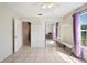 Bright bedroom with tile floors, a mirror closet, and a ceiling fan at 8337 Fussell Rd, Polk City, FL 33868