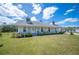 Charming home featuring a well-manicured lawn, flower beds, and a covered front porch with seating at 8337 Fussell Rd, Polk City, FL 33868