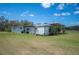 Rear exterior view of a metal building with a covered area and expansive green lawn at 8337 Fussell Rd, Polk City, FL 33868