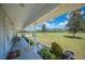 Spacious covered front porch offering serene views of the lush, expansive front lawn at 8337 Fussell Rd, Polk City, FL 33868