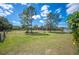 A spacious green lawn, perfect for recreation or development, framed by trees under the blue sky at 8337 Fussell Rd, Polk City, FL 33868