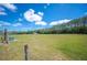 Vast open land with mature trees, blue skies, and fencing, offering privacy and scenic views at 8337 Fussell Rd, Polk City, FL 33868
