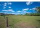 A wide view of a huge green pasture surrounded by trees under a blue sky with some clouds at 8337 Fussell Rd, Polk City, FL 33868