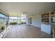 A covered patio featuring tiled flooring, ceiling fan, white double doors, and adjacent to a deep freezer and window at 8337 Fussell Rd, Polk City, FL 33868