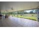 A screened-in patio showcasing tile flooring, ceiling fans, and an expansive view of the grassy yard at 8337 Fussell Rd, Polk City, FL 33868
