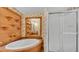 Bathroom featuring a tub, shower, custom shelving and floral wallpaper at 8341 Mitchall Dr, Lakeland, FL 33809