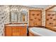 Bathroom featuring a tub, double sink vanity, custom shelving and floral wallpaper at 8341 Mitchall Dr, Lakeland, FL 33809
