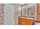 Bathroom with double sink vanity, floral wallpaper and a tile floor at 8341 Mitchall Dr, Lakeland, FL 33809