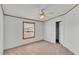 Bedroom features neutral carpet, fan, and window allowing for natural light at 8341 Mitchall Dr, Lakeland, FL 33809