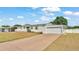 Home featuring an attached garage and a long drive, under a bright sky at 8341 Mitchall Dr, Lakeland, FL 33809