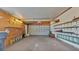 Spacious garage with shelving, lighting, and roll-up door offers ample space for storage and vehicle parking at 8341 Mitchall Dr, Lakeland, FL 33809