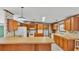 Traditional kitchen features warm wood cabinets, floral wallpaper, and modern appliances at 8341 Mitchall Dr, Lakeland, FL 33809
