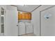 Functional laundry room includes washer, dryer, and upper cabinets for storage at 8341 Mitchall Dr, Lakeland, FL 33809