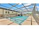 Covered, screened-in pool area with ramp and step access offers a place for Gathering fun at 8341 Mitchall Dr, Lakeland, FL 33809