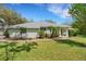 Inviting single-story home featuring mature trees, a well-manicured lawn, and a welcoming entrance at 12301 Jim Edwards Rd, Haines City, FL 33844