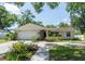 Charming single-story home with well-manicured lawn, arched entryway and white garage door at 1503 Clairdale Ln, Lakeland, FL 33801