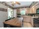 Cozy kitchen featuring neutral cabinets, black appliances, and butcher block countertop at 1503 Clairdale Ln, Lakeland, FL 33801