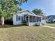 Charming one-story home featuring a screened-in porch, blue shutters and a well-maintained front lawn at 319 E Johnson Ave, Lake Wales, FL 33853
