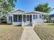 Inviting one-story home with a sunny yellow front door, screened-in porch and well-manicured lawn at 319 E Johnson Ave, Lake Wales, FL 33853