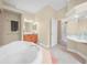 Bright bathroom featuring a large soaking tub and separate vanity area, offering a spa-like experience at 3300 Hawks Ridge Dr, Lakeland, FL 33810